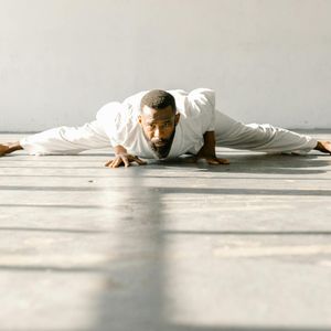 Silhouette of a man stretching in low light.